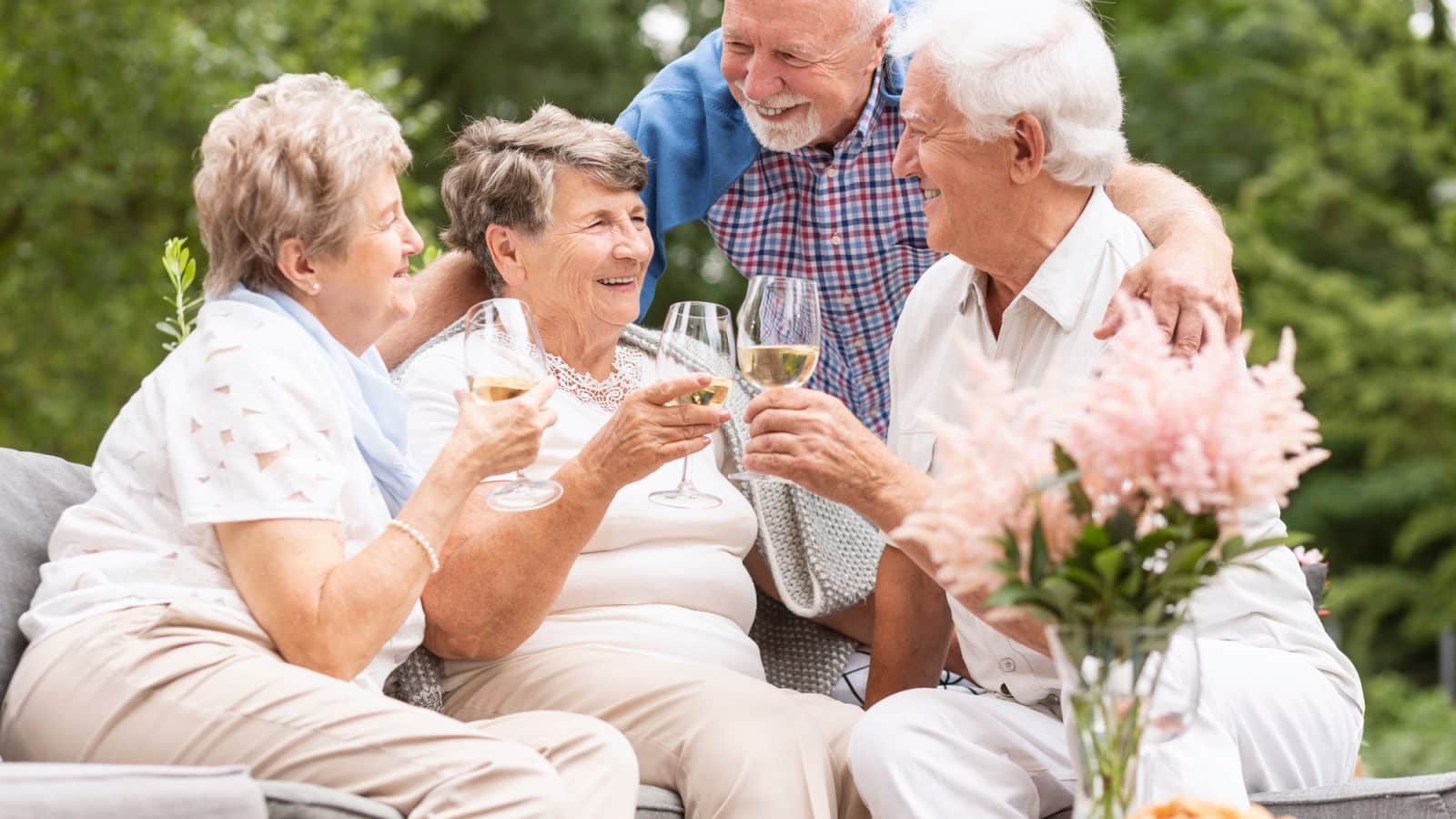 Happy and smiling senior people drinking wine on the terrace dur